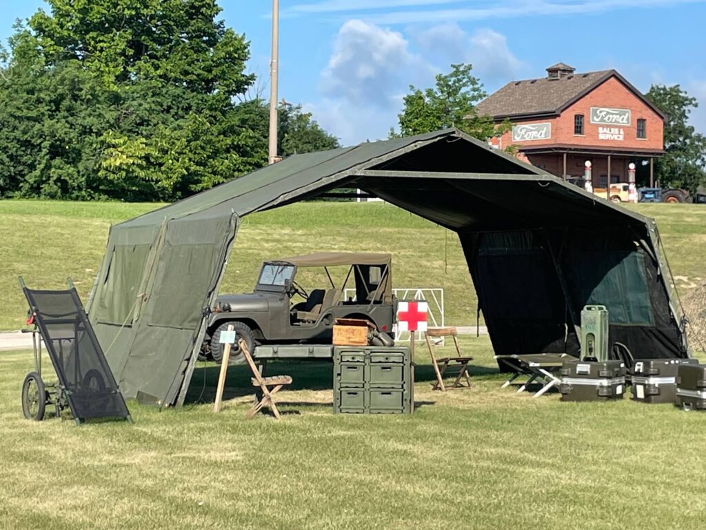 Vintage military jeep and tent with various army supplies